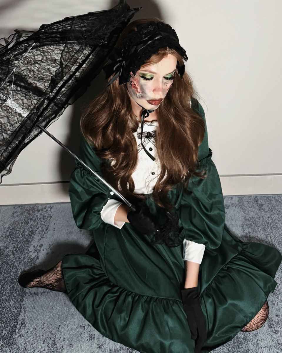 Victorian doll character in green silk with cracked painted skin and a lace parasol