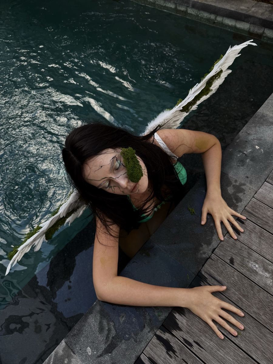 Drowned angel: moss and veining across the face, feathered wings, shot in water